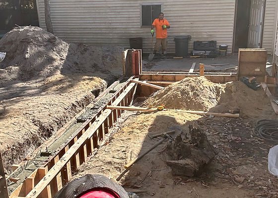 Foundation forms set beside a house for new construction