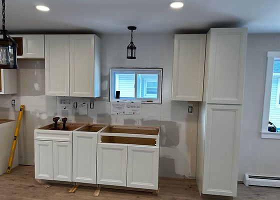 White kitchen cabinets partway through installation